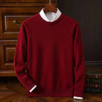 Front view of a deep red crew neck jumper layered over a white collared shirt, displayed on a wooden hanger