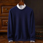 Navy blue crew neck jumper with ribbed collar and cuffs, displayed on a wooden hanger against a dark panelled wall