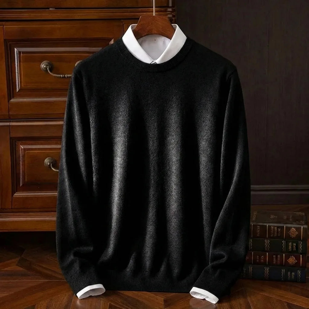 Black crew neck knit jumper with subtle textured pattern, layered over a white shirt collar on a wooden hanger