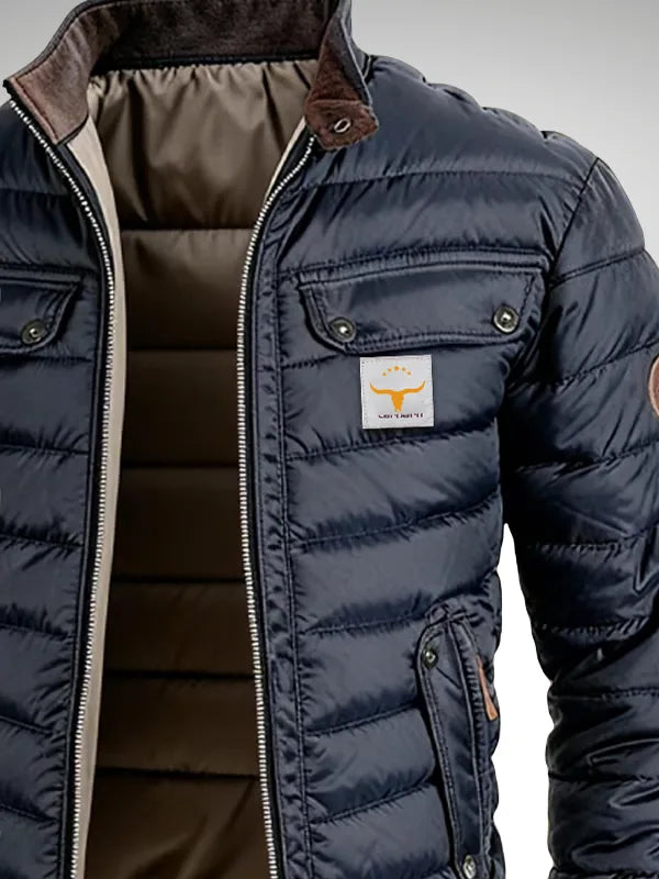 Detail of chest pocket, woven bull logo patch and ribbed cuffs on the navy quilted puffer jacket