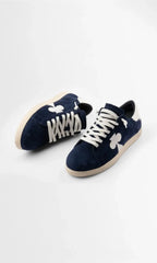 Overhead angled view of both trainers showing the padded tongue, white laces and textured suede upper