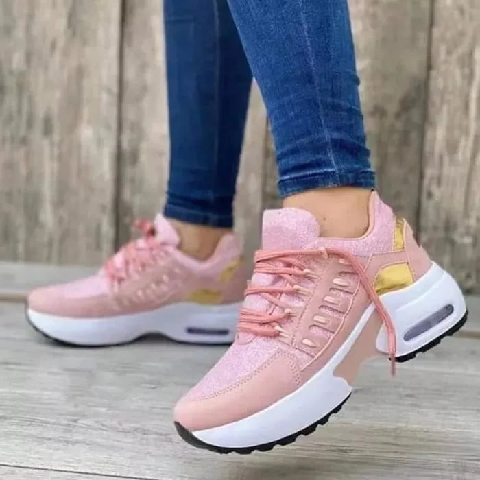 Pink glitter trainers with gold panel detail and white chunky sole, worn with blue skinny jeans