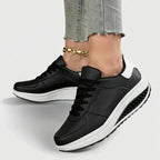 Close-up of black lace-up trainers with white heel panel and white platform wedge sole