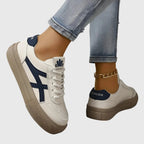 Close-up back view of white trainer with navy heel panel reading Fashion and chunky beige sole