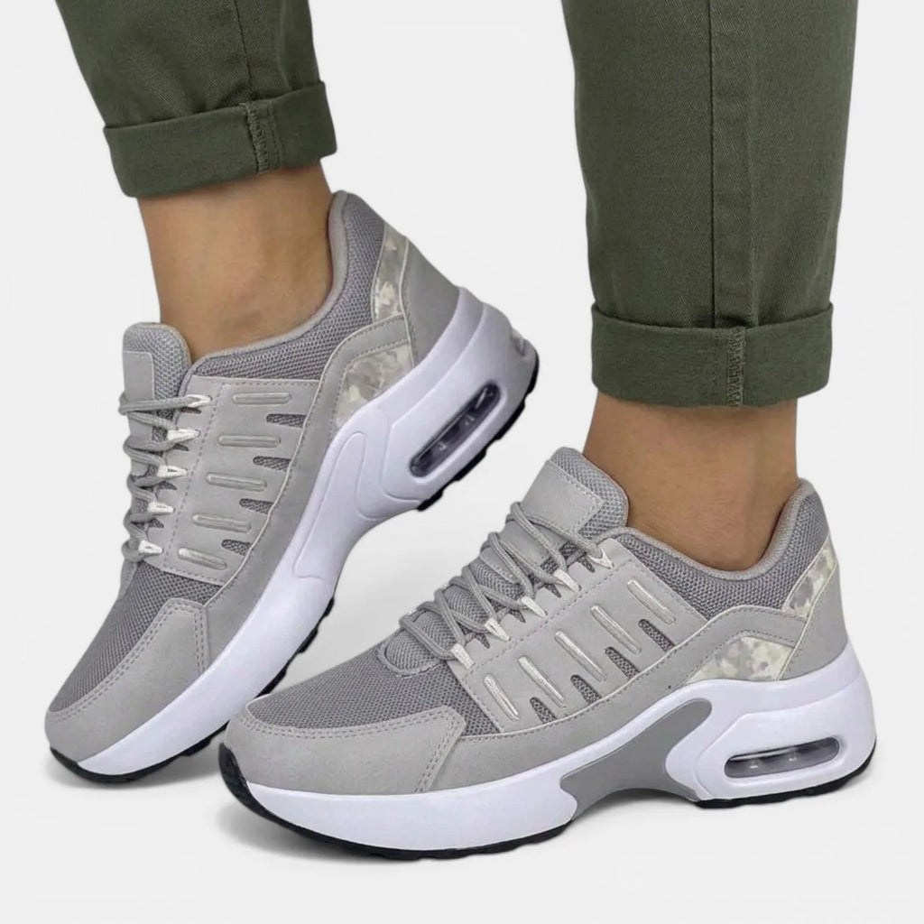 Side profile of grey chunky trainers with camouflage-print heel panel and white platform sole