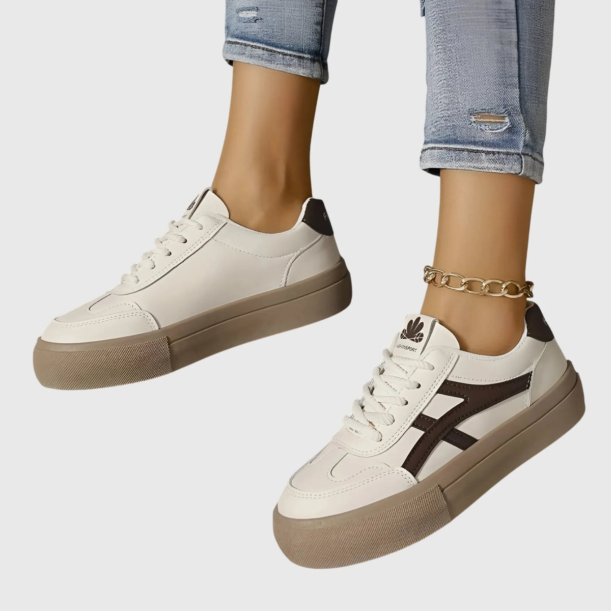 Front and back view of white trainer with brown stripe and brown heel tab worn with cuffed jeans