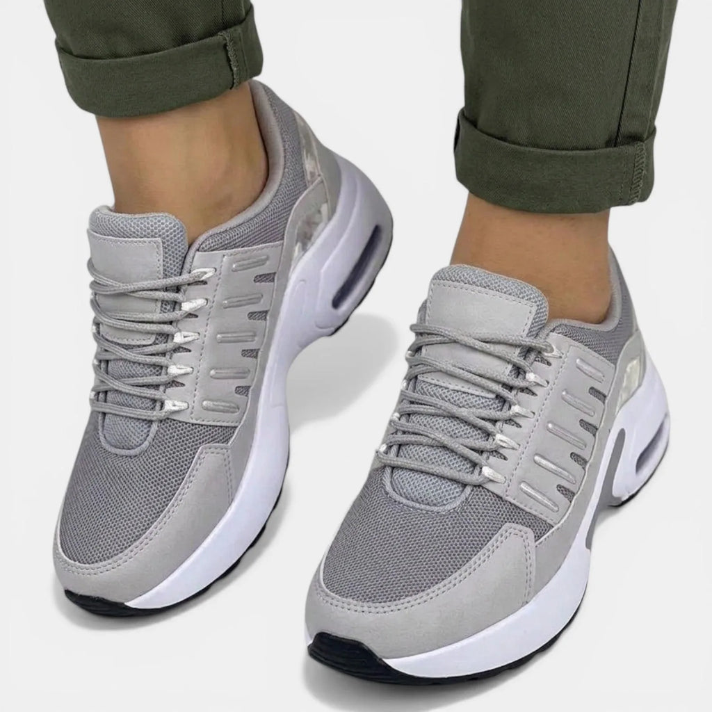 Front view of grey mesh trainers with silver-tone eyelets and lace-up front