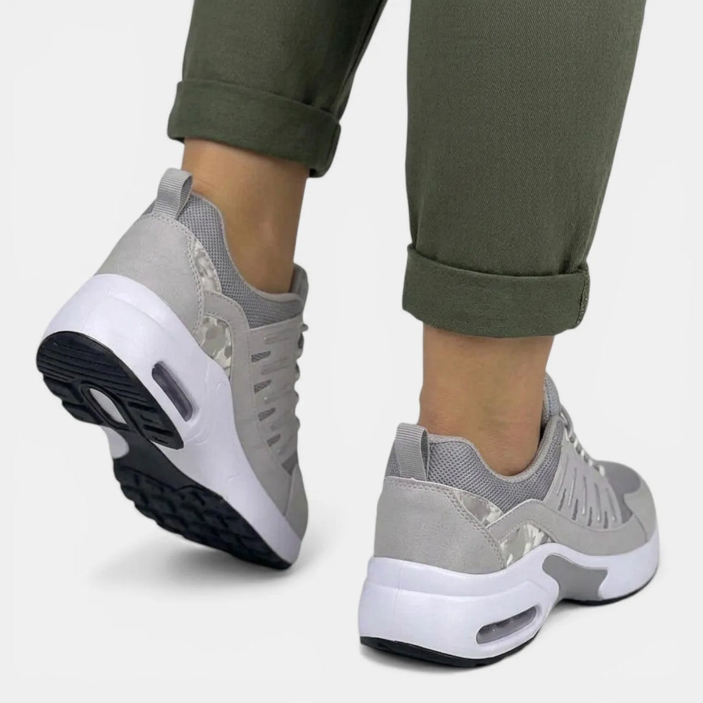 Back view of grey trainers highlighting the textured heel pull tab and white midsole