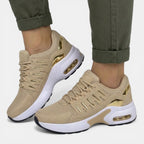 Side angle of beige suede-look trainers with metallic gold panel accents and white sole