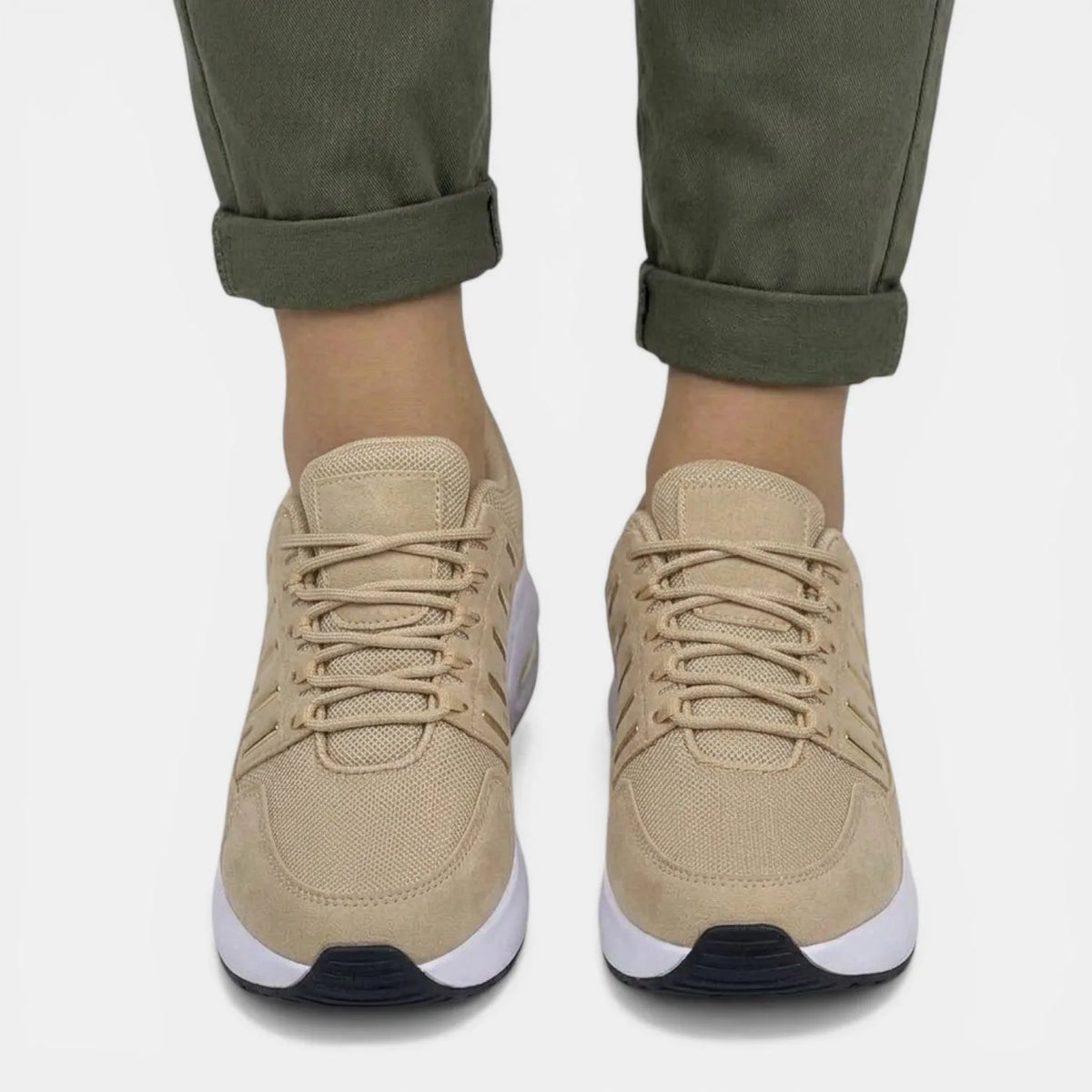 Front view of beige trainers showing mesh toe cap and gold-tone eyelets