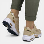 Close crop of beige trainer uppers worn with turned-up khaki trouser hems