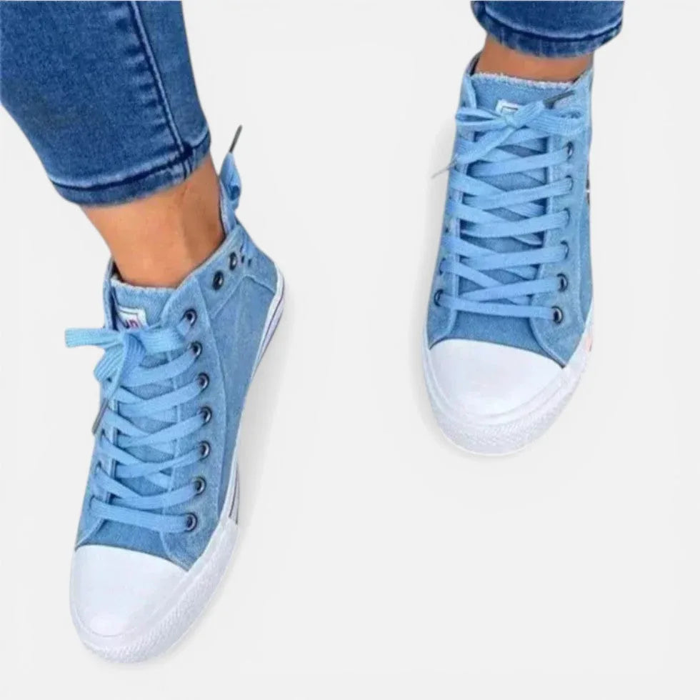 Front view of light blue denim high-top trainers laced up, showing white toe caps and round eyelets