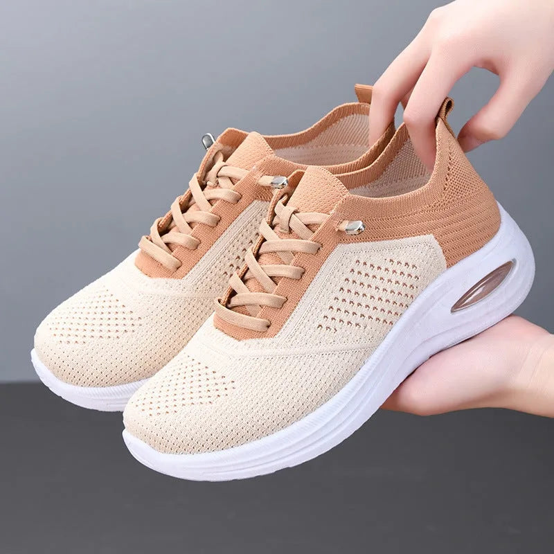 Side profile of beige knit trainer with tan heel and collar panel, laced front and chunky white sole with air cushion detail