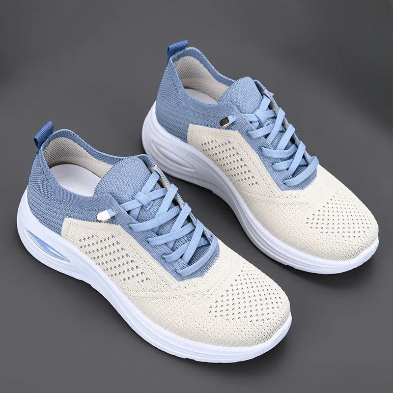 Pair of blue and cream knit trainers shown from above, laced closure and white sole with visible air cushion unit