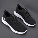 Pair of black mesh trainers with white laces, metallic eyelets and two-tone white midsole with black tread