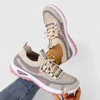 Pair of beige knit trainers with dusty pink sole and contrast panels, one worn and one held up