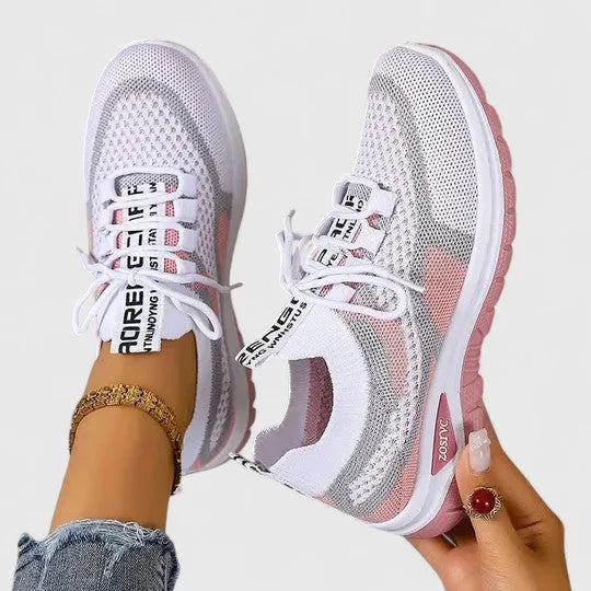 White knit trainers with pink accents and lace-up front, worn together showing matching pair from above