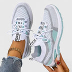 White and mint green knit trainers worn on foot with cushioned sole detail visible from the side