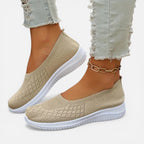 Beige knit slip-on trainer with diamond stitch pattern, worn with light denim and a chain anklet