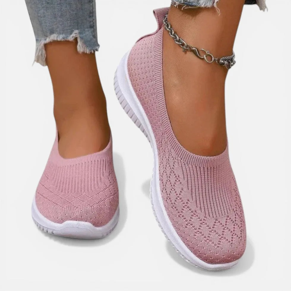Pink knit slip-on trainer front view, low-cut vamp and white ribbed sole shown in detail
