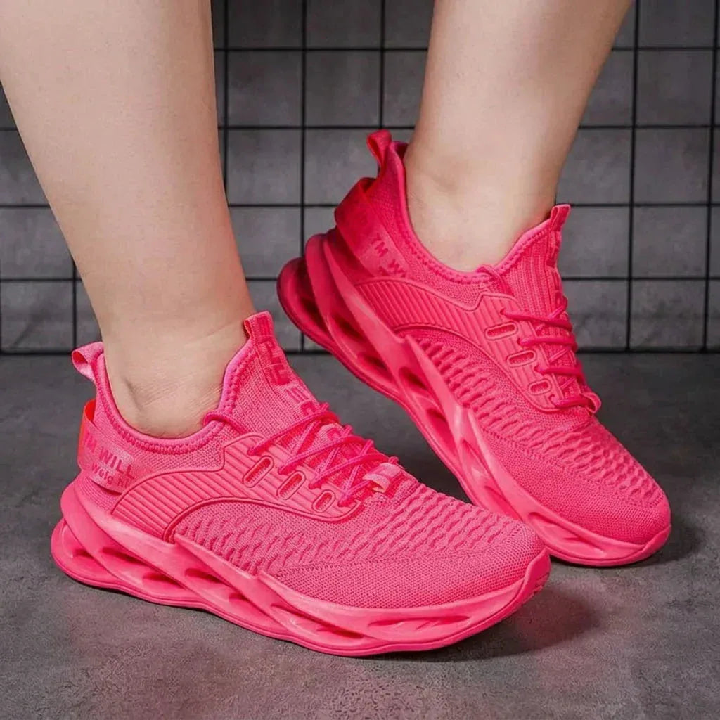 Close-up of the knit upper and bold outsole cutouts on a pink and purple gradient trainer