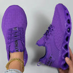 Top-down and side view of a pair of purple knit trainers showing the ribbed side panel and tunnel sole