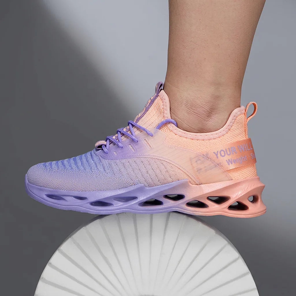 Back three-quarter view of a pair of pink and purple gradient trainers on wooden flooring