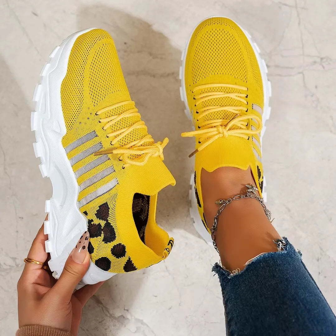Overhead view of mustard yellow knit trainers with grey stripes and leopard print lining detail