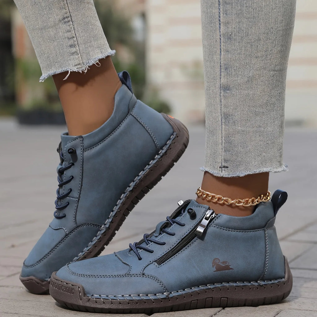 Cream leather high-top sneaker shown beside its pair, highlighting the padded collar and heel pull tab