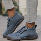 Cream leather high-top sneaker shown beside its pair, highlighting the padded collar and heel pull tab