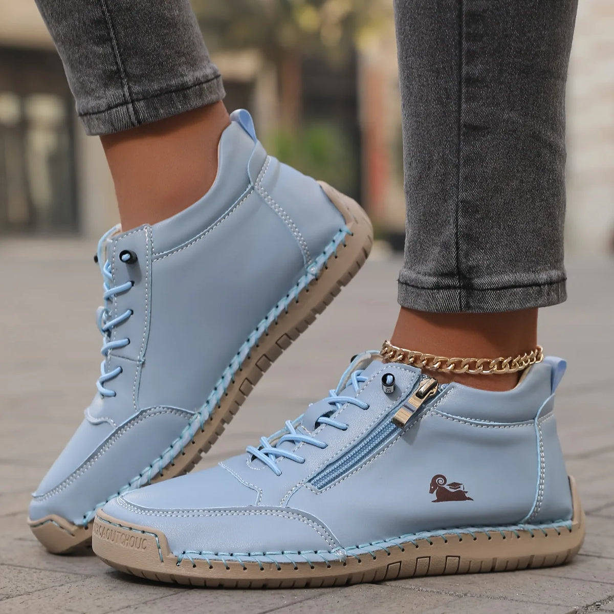 Tan leather high-top trainer with contrast stitched toe cap and side zip, paired with light wash denim