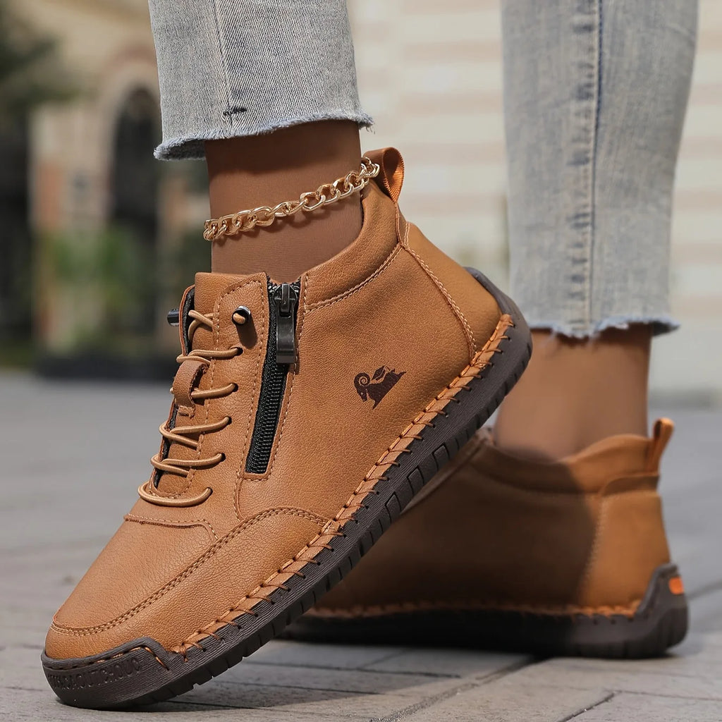 Light blue leather high-top trainer with gold anklet accessory, laces and zip pull in sharp focus