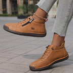 Angled view of camel brown leather ankle sneaker mid-stride, showing zip, laces and ram logo detail