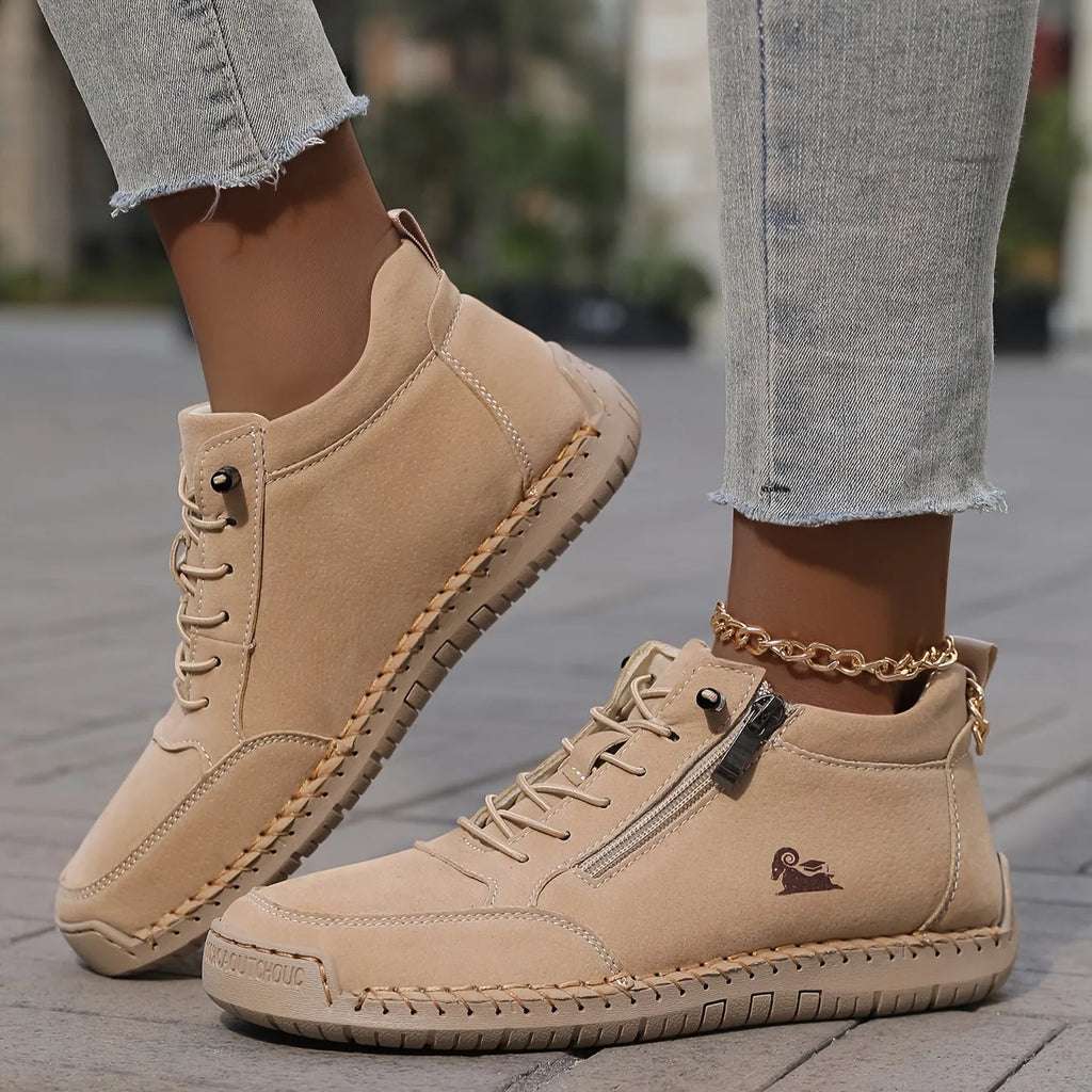Front view of sage green leather ankle trainer paired with cropped raw-hem jeans and a gold anklet