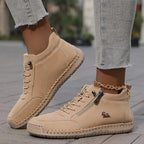 Front view of sage green leather ankle trainer paired with cropped raw-hem jeans and a gold anklet