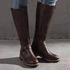 Front angle of dark brown leather knee-high boots showing side zip and stacked block heel