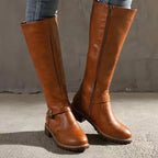 Front view of tan brown leather knee-high boots with rounded toe and treaded sole