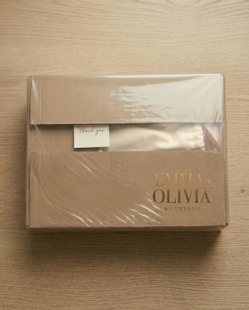 Kraft gift box with tissue paper and a thank you note, shown closed on a wooden surface
