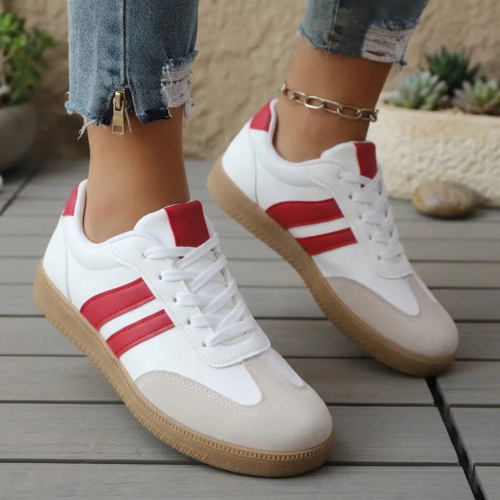 Pair of red and white lace-up trainers shown on feet, highlighting ribbed heel tab and contrast stripes