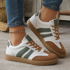 Angled close-up of the red heel tab and double stripe detail on a white leather trainer