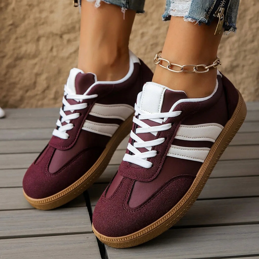 Pair of green and tan trainers shown from above with ankle bracelet visible, laces tied in tan cord