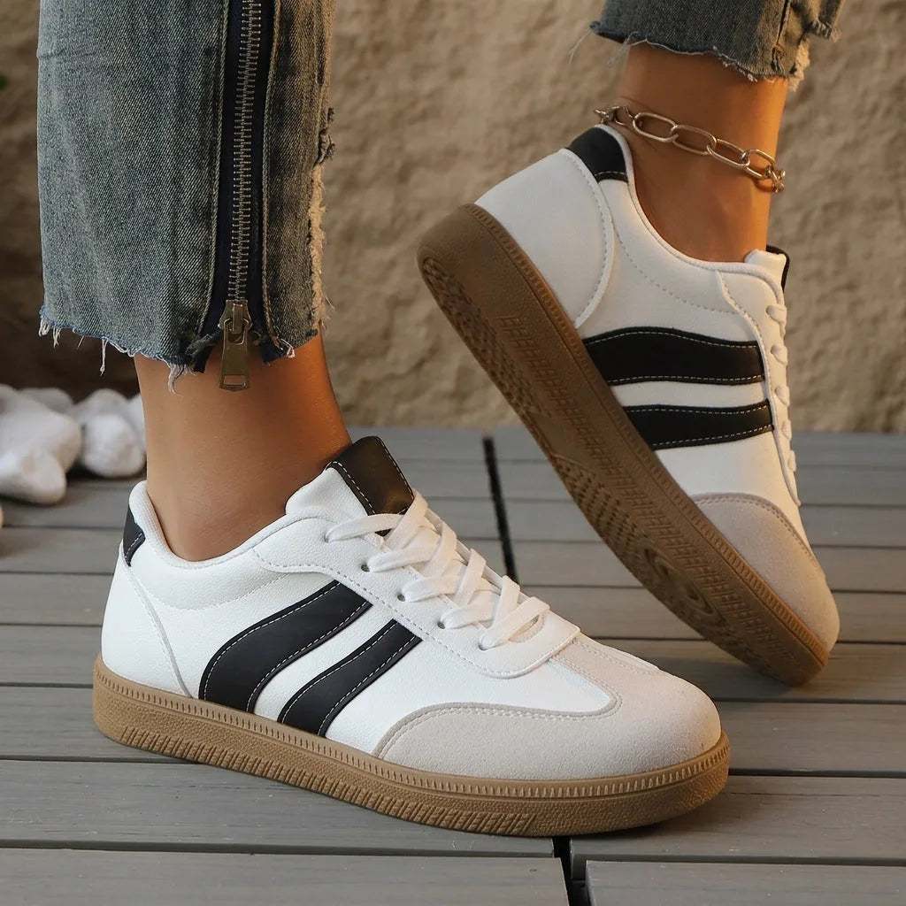 Maroon and white trainers with double stripe detail and gum sole, shown from a side angle outdoors