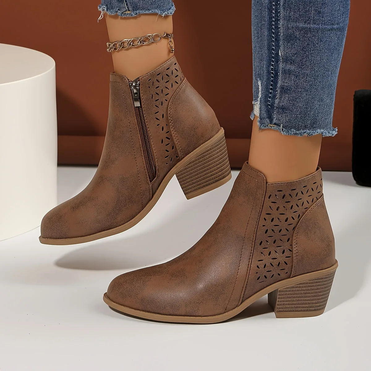 Both black ankle boots shown together from the side, showcasing matching perforated panels and heel height
