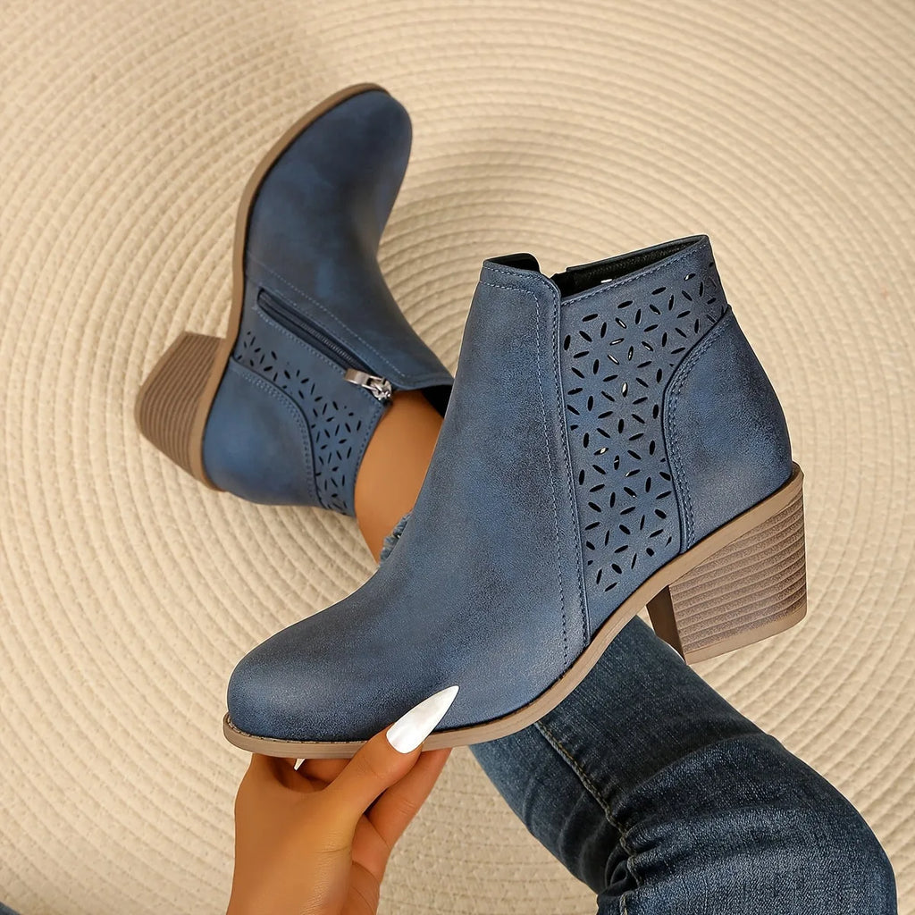 Pair of black perforated leather-look ankle boots viewed from behind, showing block heel construction