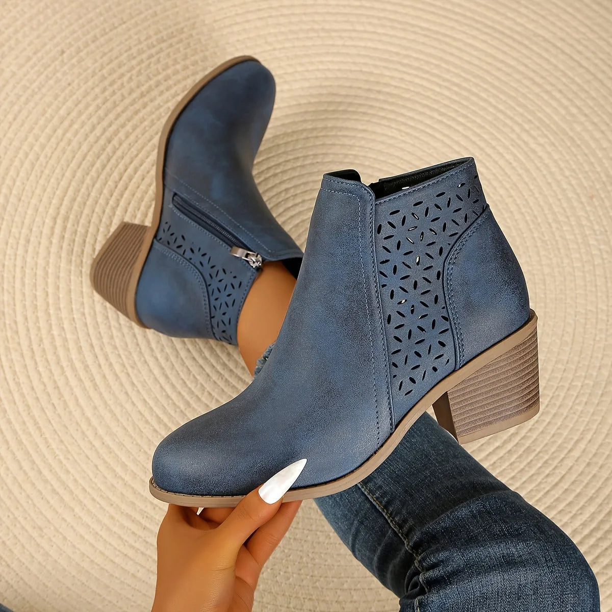 Pair of black perforated leather-look ankle boots viewed from behind, showing block heel construction