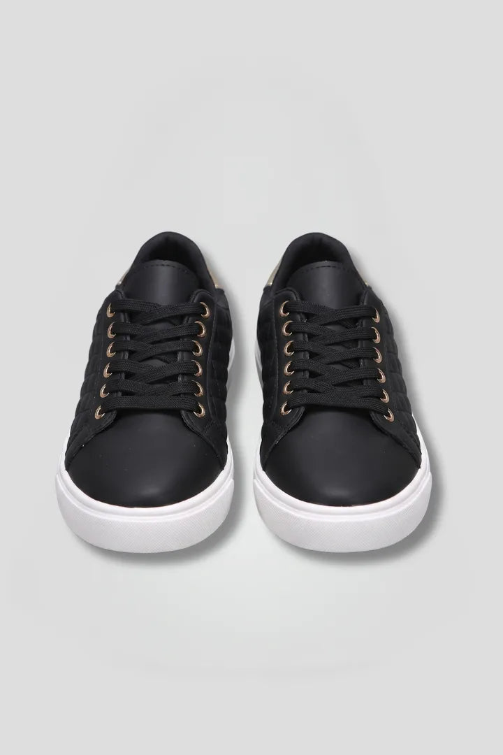 Front view of black quilted lace-up trainers with white soles, shown together facing forward
