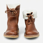 Front view of a pair of brown leather boots with the shearling cuff folded down, one up and one rolled
