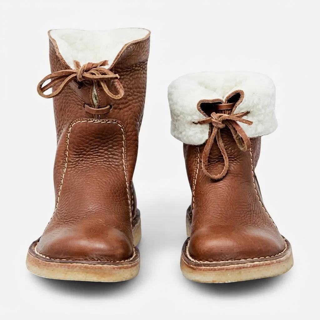 Front view of a pair of brown leather boots with the shearling cuff folded down, one up and one rolled