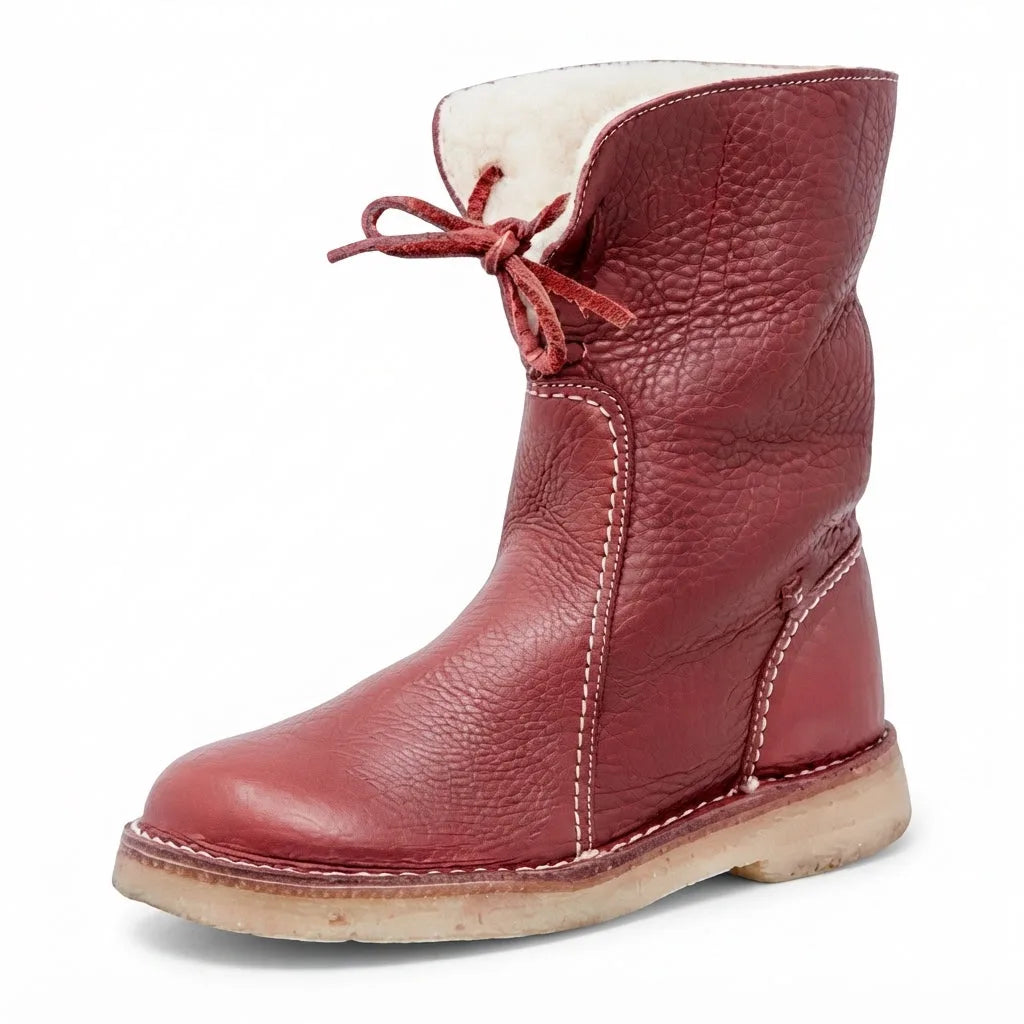 Three-quarter view of the boot in deep red leather with cream shearling cuff and matching leather laces