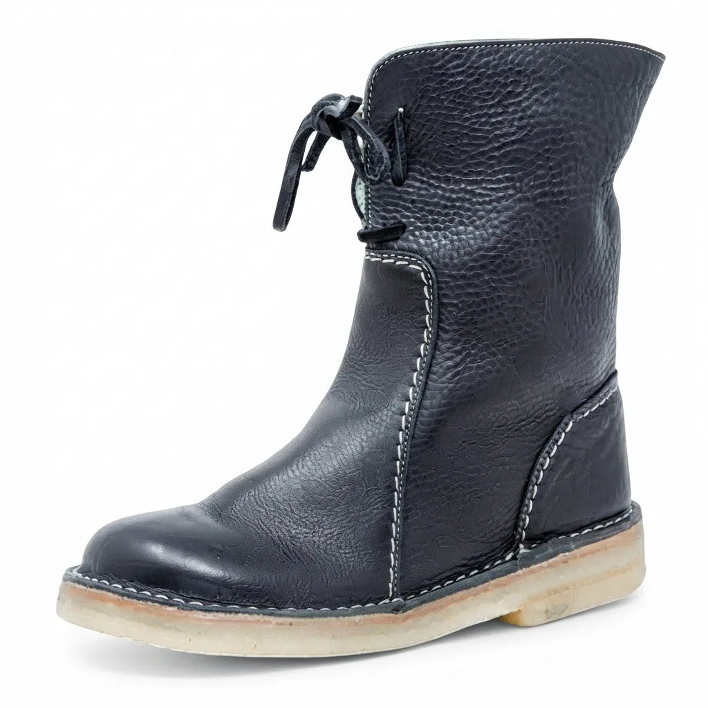 Three-quarter view of the boot in black leather with pale shearling cuff peeking at the top